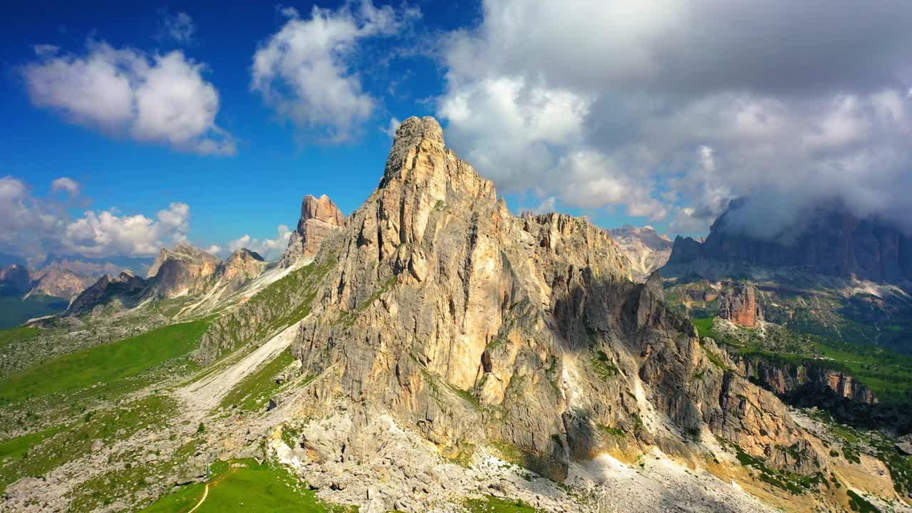 空中天然岩层对抗多云的天空，无人机飞过绿色景观- Giau Pass，意大利视频素材