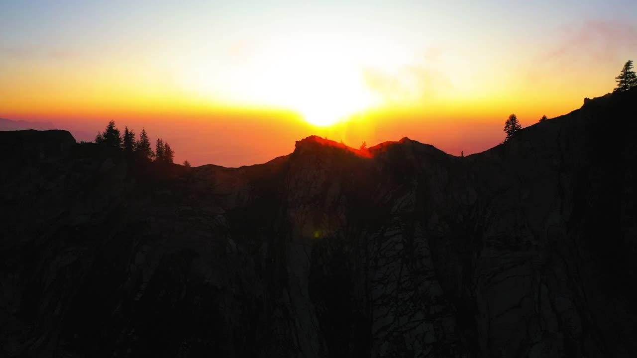 空中壮丽的照片在山顶上的树木在夕阳下橙色多云的天空-莫因角，瑞士视频素材