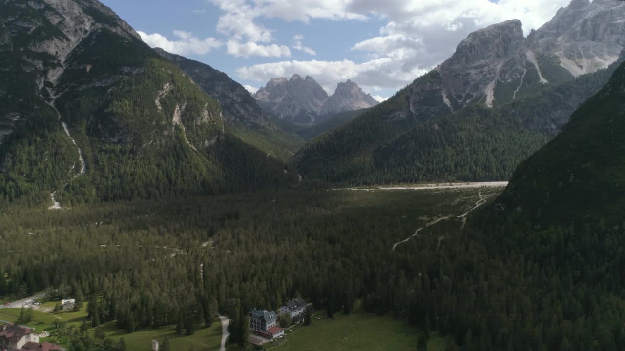 空中美丽的白云石山反对多云的天空，无人机飞行在绿色景观视频素材