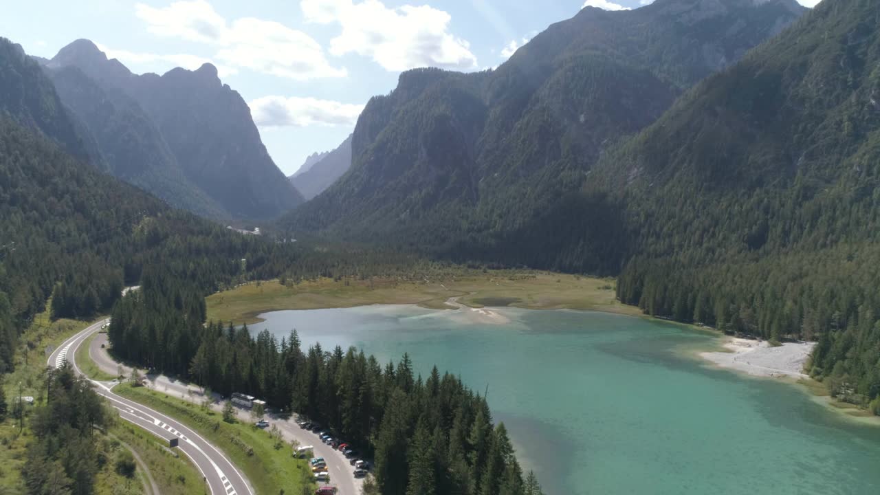 空中风景湖在绿色的山脉，无人机向下飞行的道路白云石，意大利视频素材