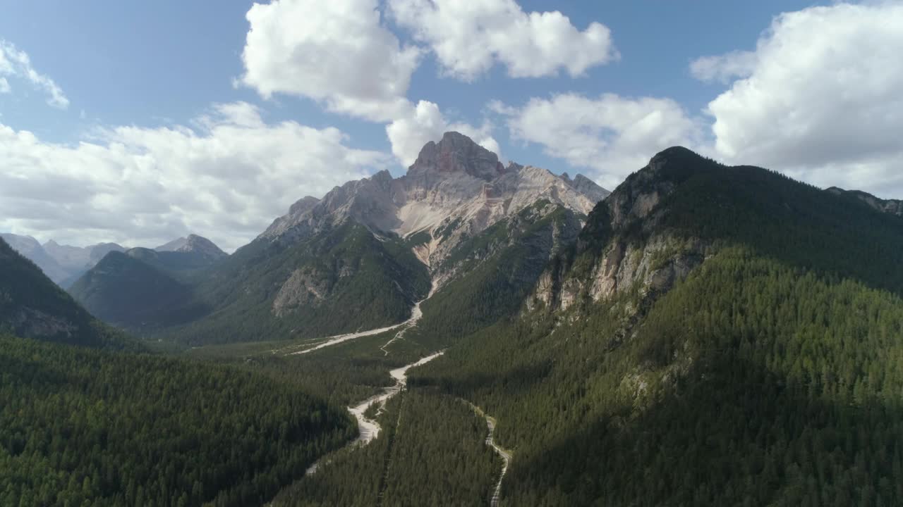 空中风景拍摄白云石山上的森林，无人机向后飞行在道路上视频素材