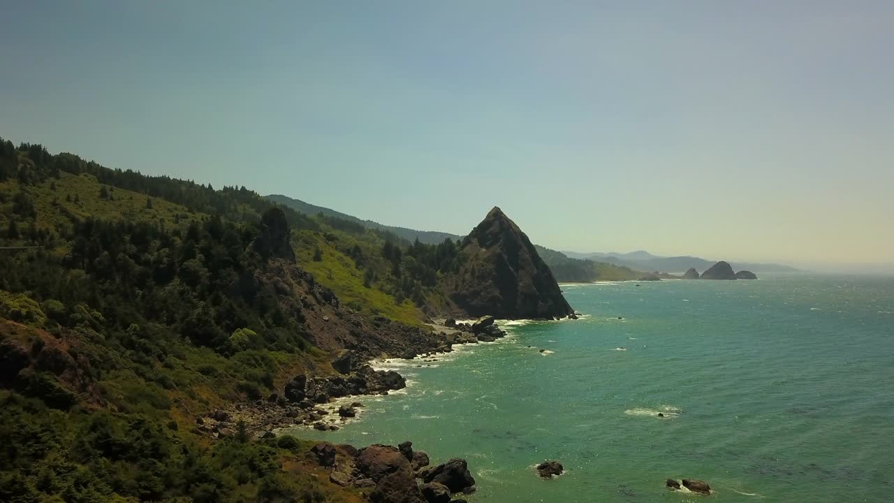 航拍海浪冲击海岸线反对蓝天，无人机在阳光明媚的日子在海上向前飞行-俄勒冈海岸，俄勒冈州视频素材