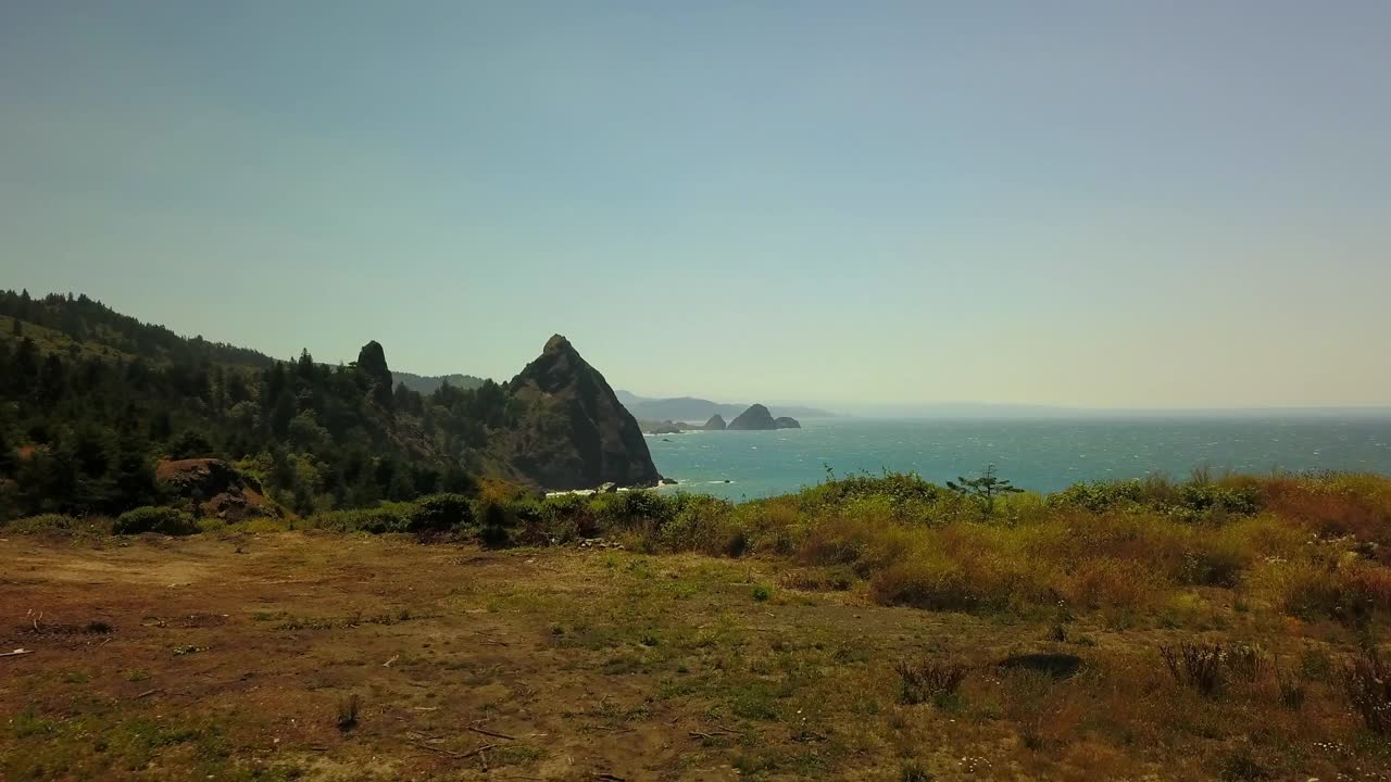 航拍:无人机在阳光明媚的日子里飞过美丽的海岸线，蓝色的天空-俄勒冈海岸，俄勒冈州视频素材