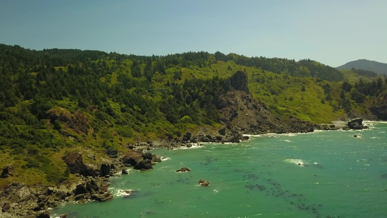 航拍拍摄的海浪冲击海岸线在阳光明媚的日子，无人机飞越大海反对蓝天-俄勒冈海岸，俄勒冈视频素材