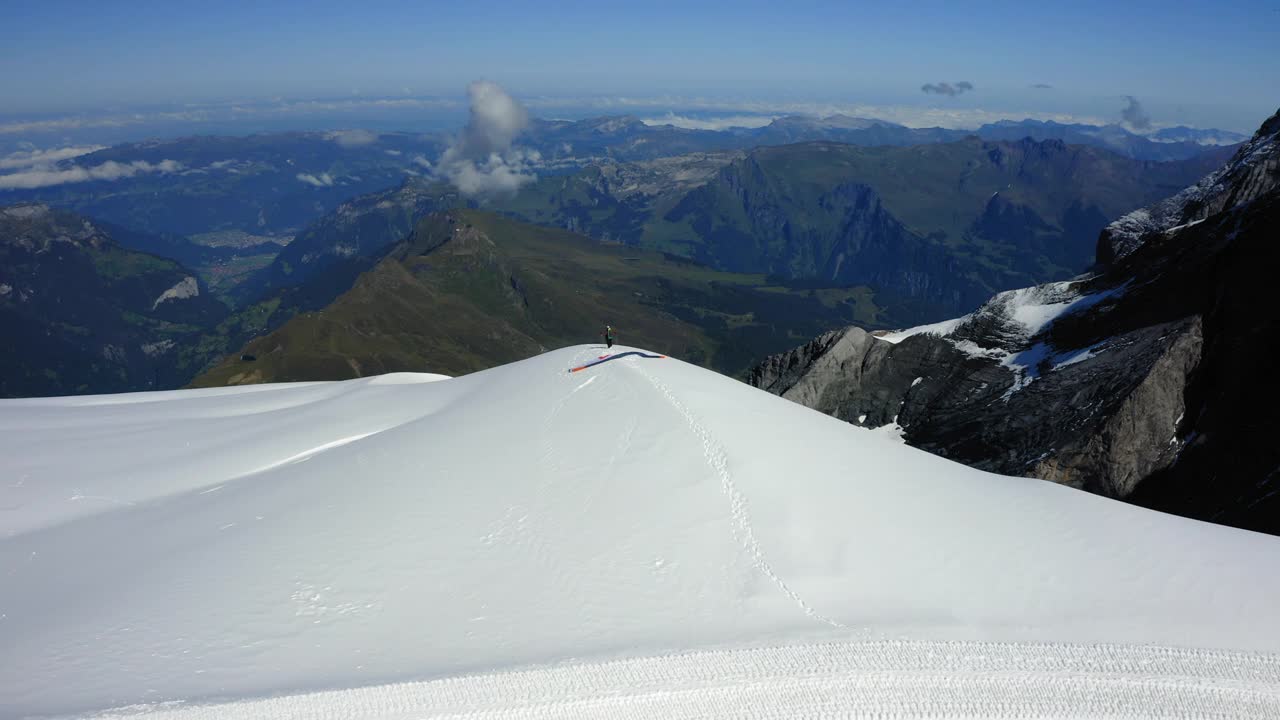 空中向前拍摄的人尝试滑翔伞飞越高山，无人机在雪上向前飞行-劳特布鲁嫩，瑞士视频素材