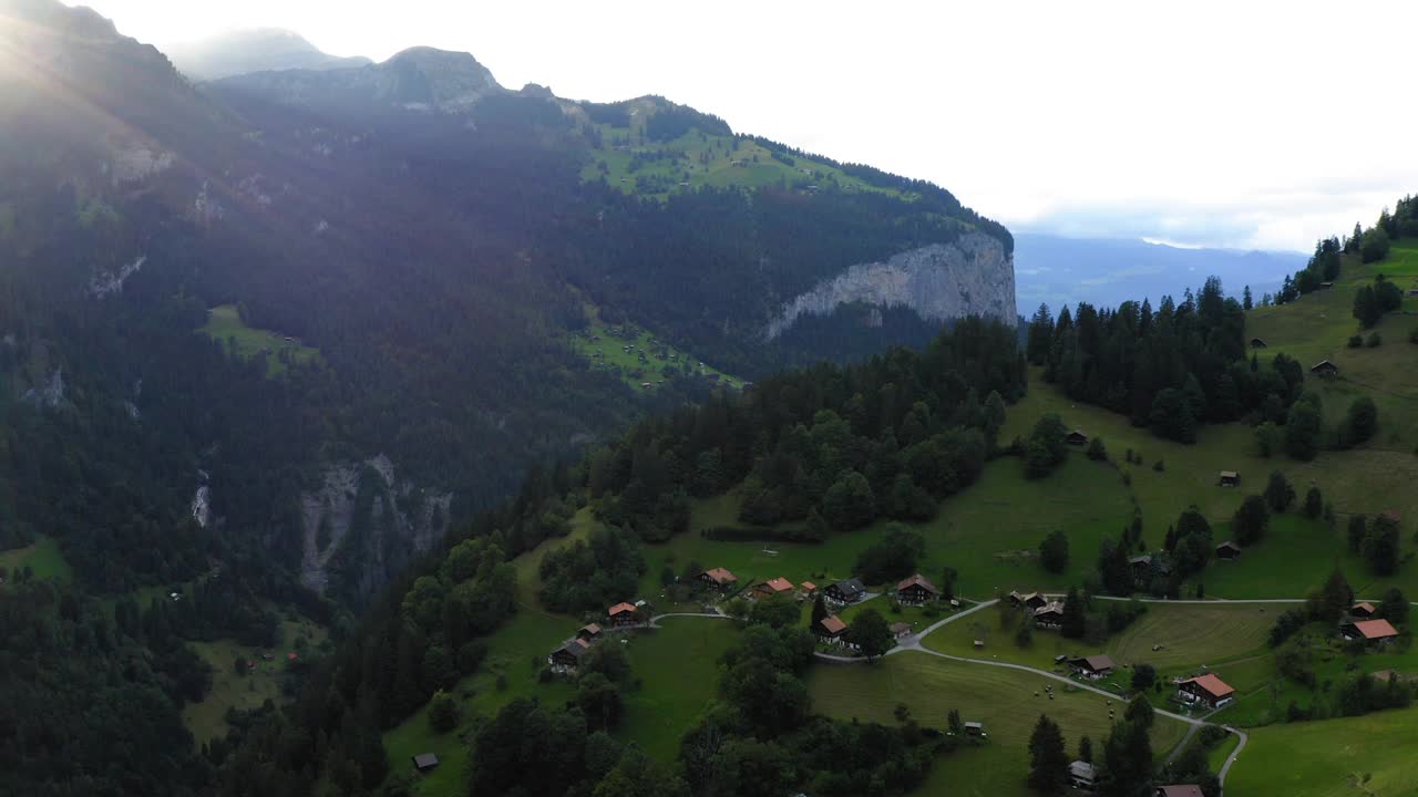 空中前进风景拍摄的房子在绿色的山景观- Lauterbrunnen，瑞士视频素材