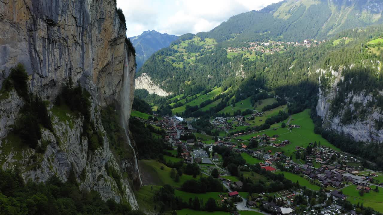 空中前进风景拍摄的住宅在村庄，无人机飞行向前在绿色景观- Lauterbrunnen，瑞士视频素材