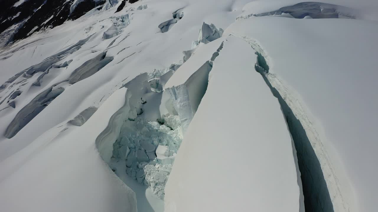 空中前进的美丽镜头，在阳光灿烂的日子积雪覆盖的土地裂缝- Lauterbrunnen，瑞士视频素材