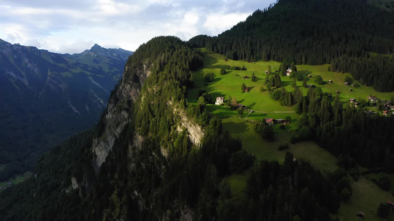 在多云的天空上绿色岩石形成的房子的美丽的视图- Lauterbrunnen，瑞士视频素材