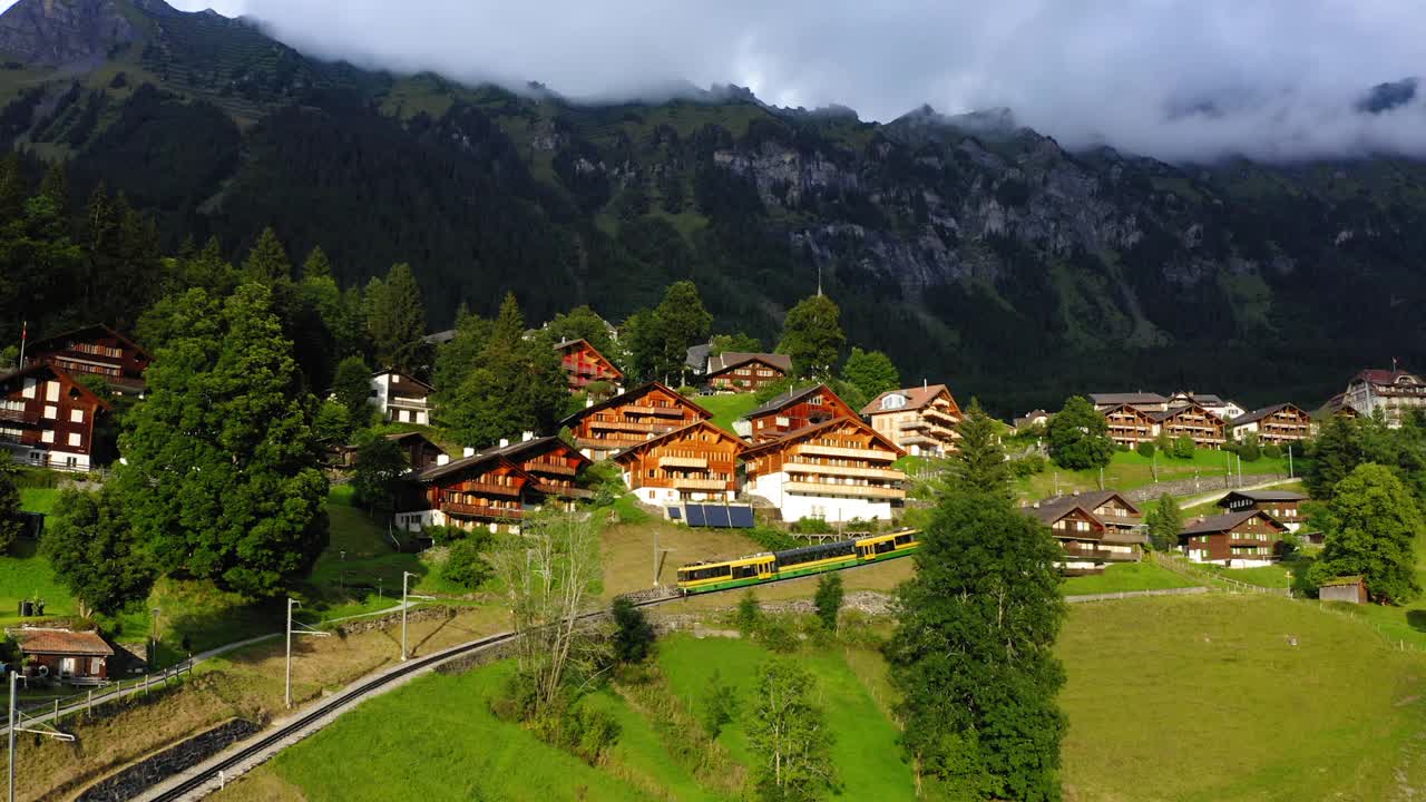 铁路在村庄轨道上移动的空中美丽镜头，无人机飞过绿色景观- Lauterbrunnen，瑞士视频素材