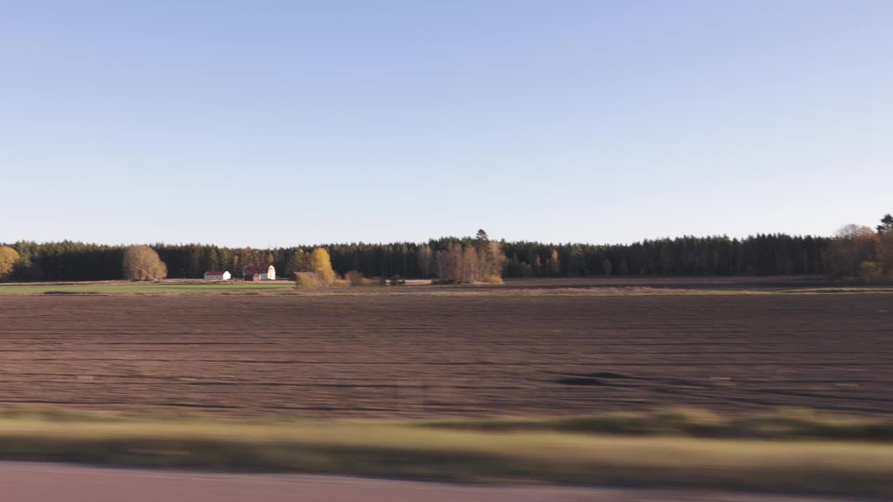 美丽的秋日和车上的风景。美丽的风景有田野，森林树木和蓝天白云。瑞典。视频素材