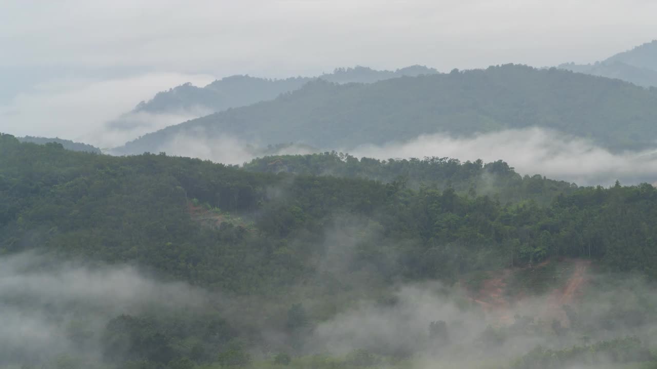 时隐时现的云在阴天的山上流动，在夏天的日出景象视频素材