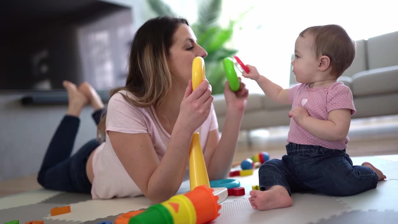 一位妇女在客厅里和她的婴儿玩耍视频素材