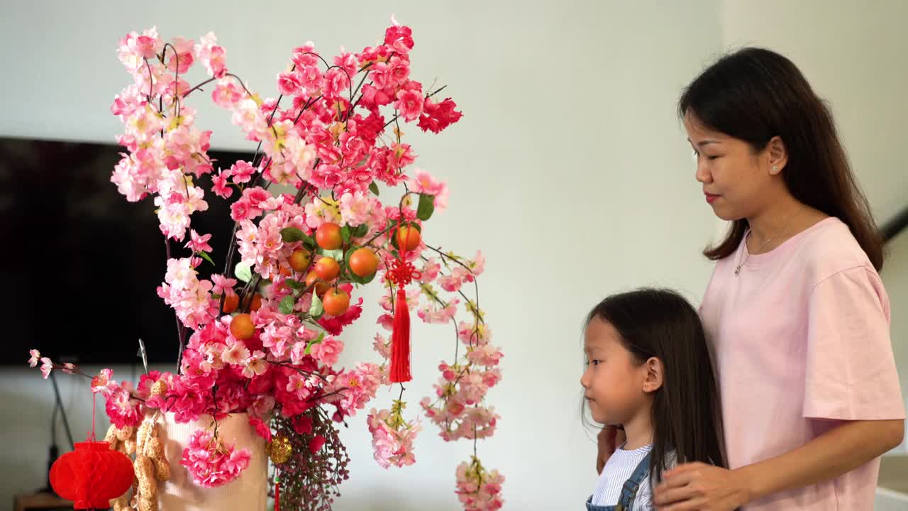 母亲和女儿装饰客厅庆祝中国新年视频素材