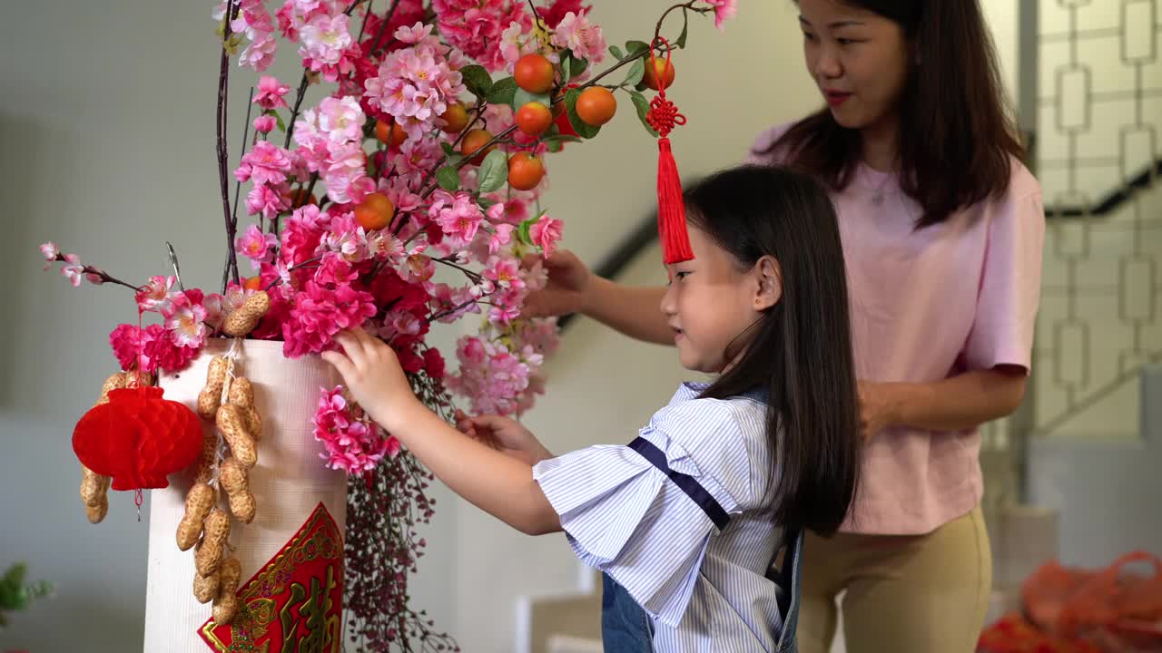 母亲和女儿装饰客厅庆祝中国新年视频素材