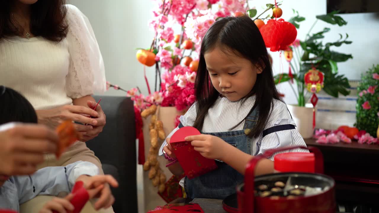 小孩子在客厅里准备春节红包视频素材