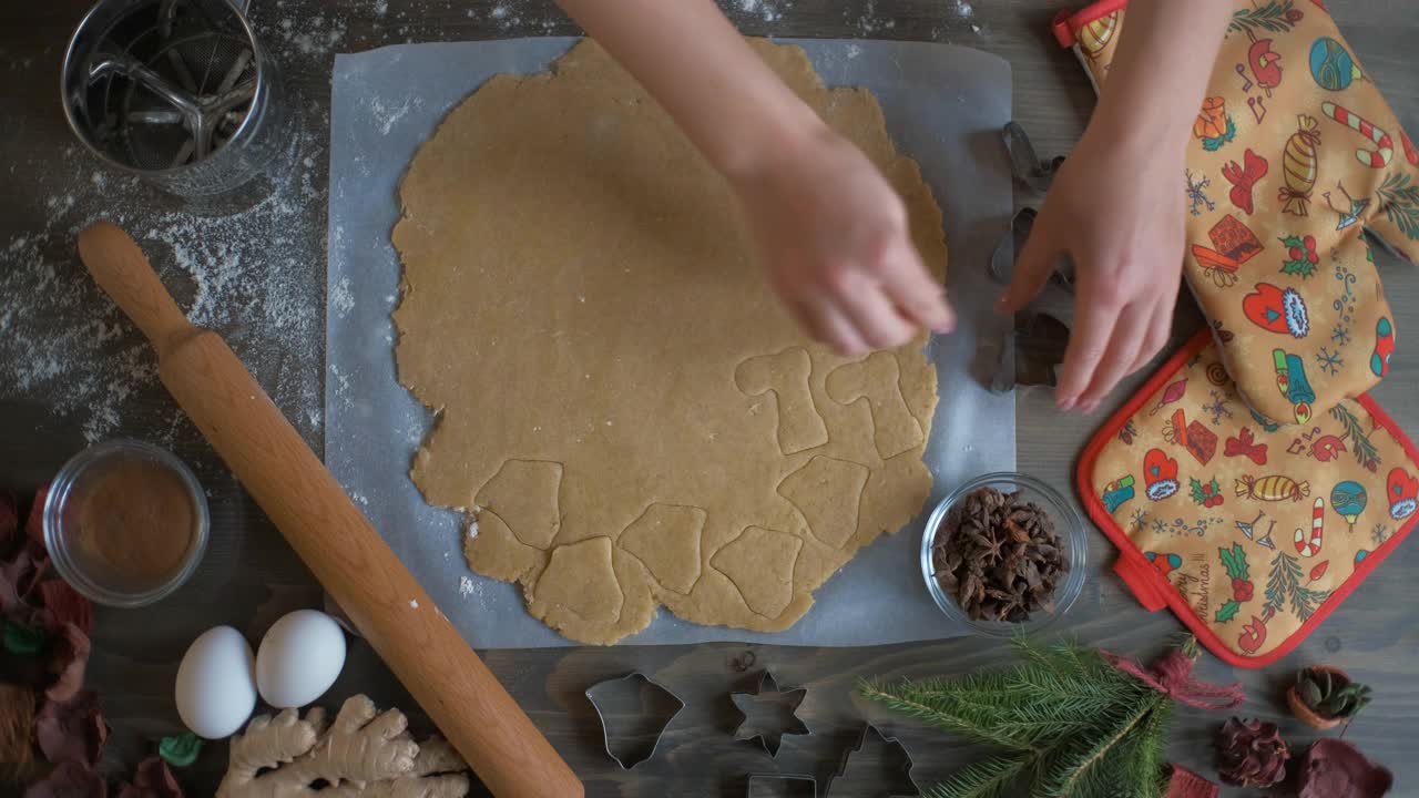 一位女士正在为圣诞节准备姜饼饼干。切割开始，天使和圣诞树视频素材