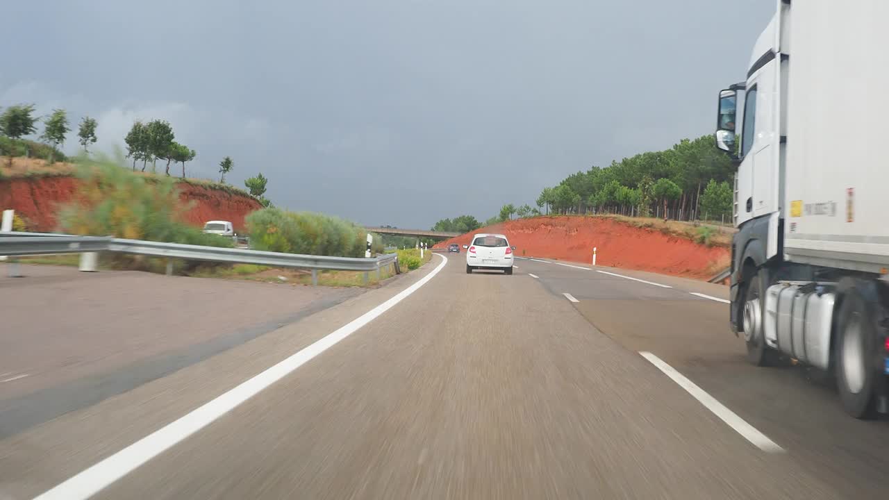 汽车视角驾驶，汽车行驶在潮湿的公路上，弯道和雨。视频素材