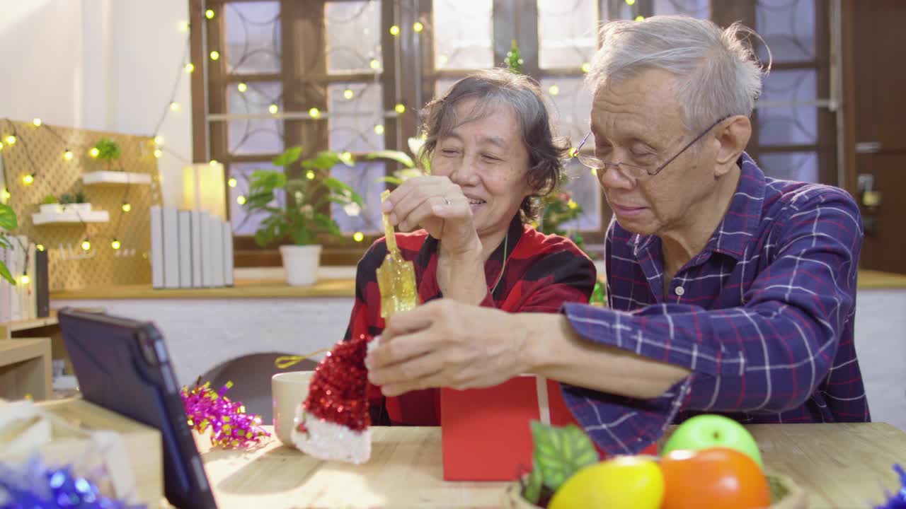 在庆祝圣诞节期间，一对活跃的中国老夫妇在公寓里用笔记本电脑与孙女进行视频会议视频素材