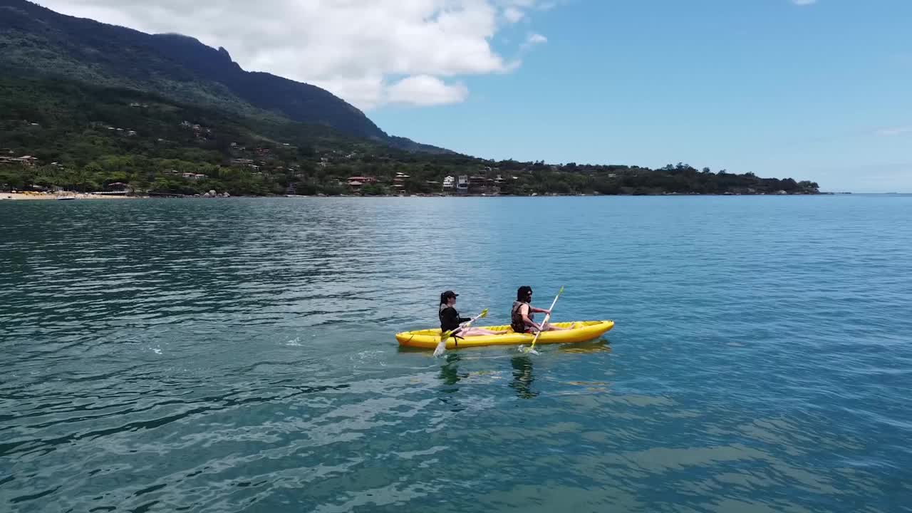 朋友们在海边玩黄色皮艇视频素材