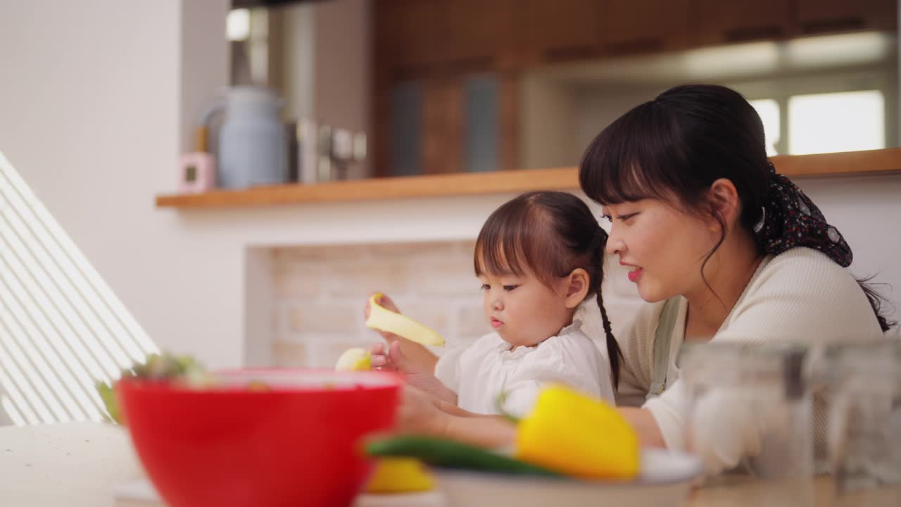 妈妈帮她的小女儿做冰沙，鼓励她健康饮食视频素材