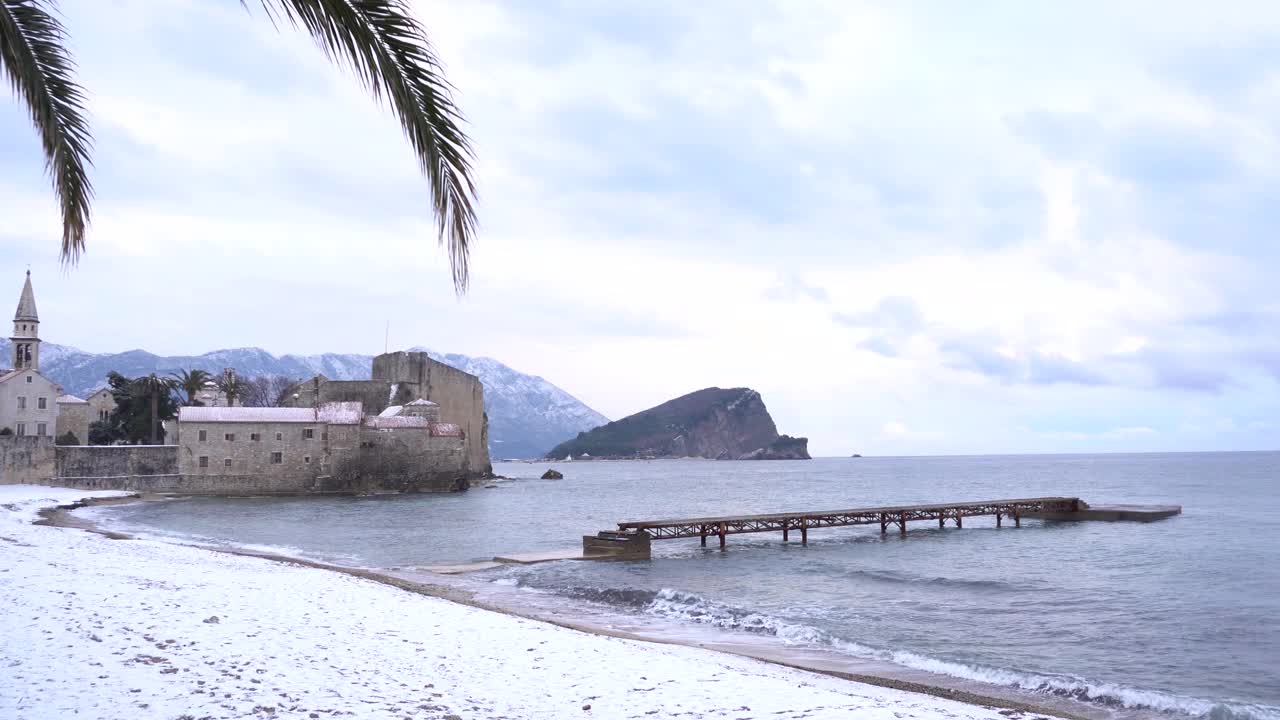 布达瓦老城附近的码头，背景是白雪覆盖的海滩视频素材