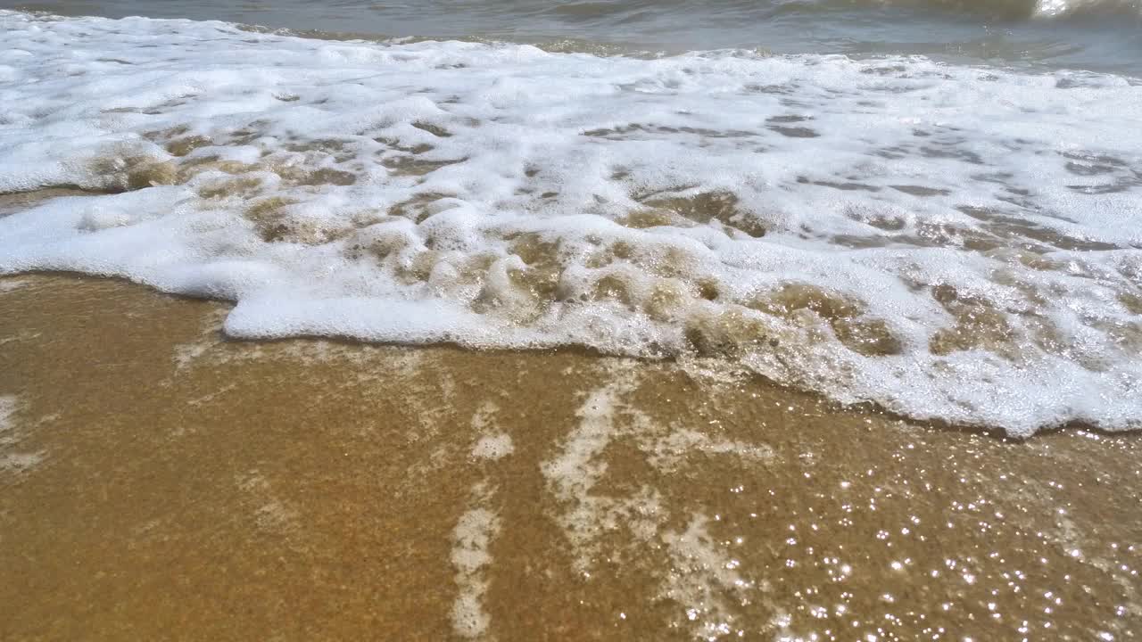 海浪卷上白色沙滩的特写镜头视频素材