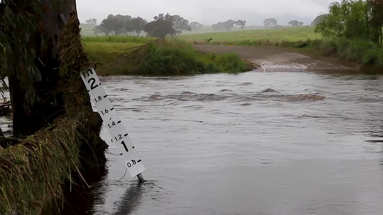 洪水深度指示器显示洪水穿过乡村道路的深度视频素材