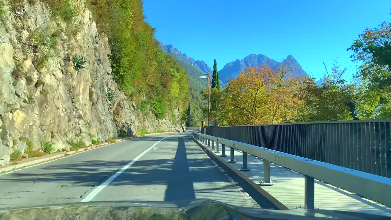 在一个阳光明媚的日子里，在山路上与卢加诺高山湖的汽车视角视频素材