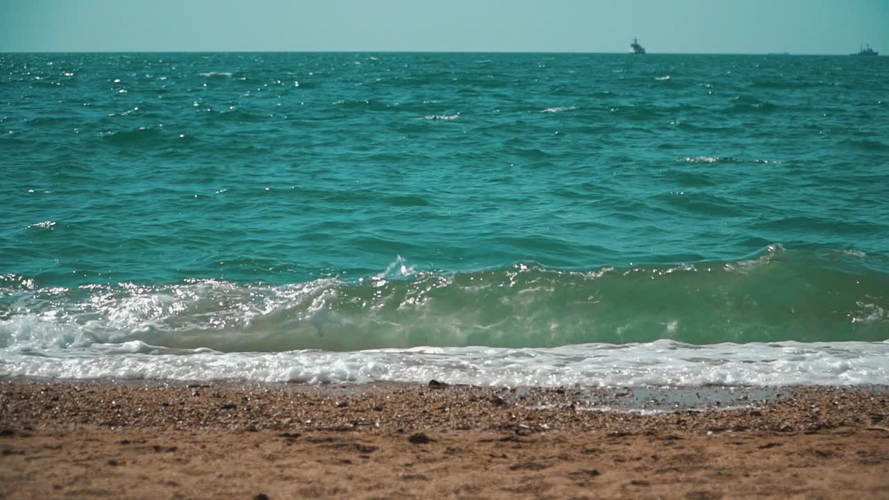 海浪在阳光明媚的岸边视频下载