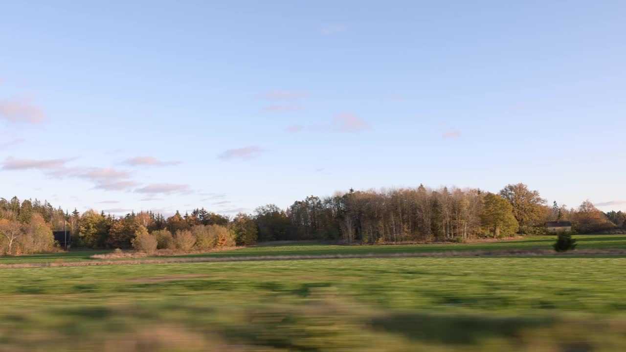 美丽的秋日和车上的风景。美丽的风景有田野，森林树木和蓝天白云。瑞典。视频素材