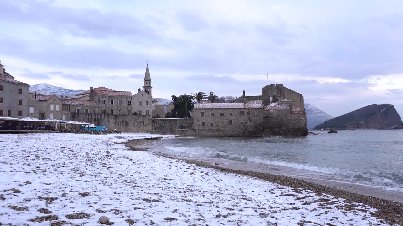 白雪覆盖的海滩在布德瓦城堡的背景视频素材