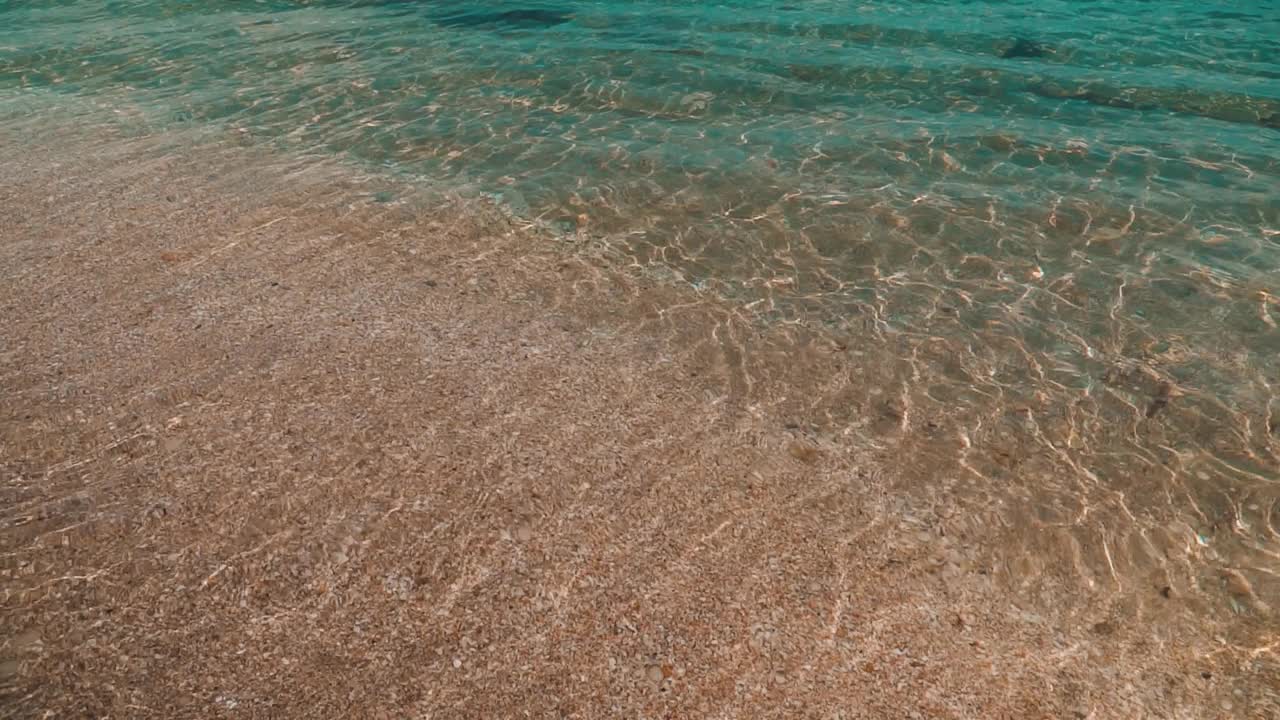 清澈的海水轻轻地拍打着沙滩视频素材