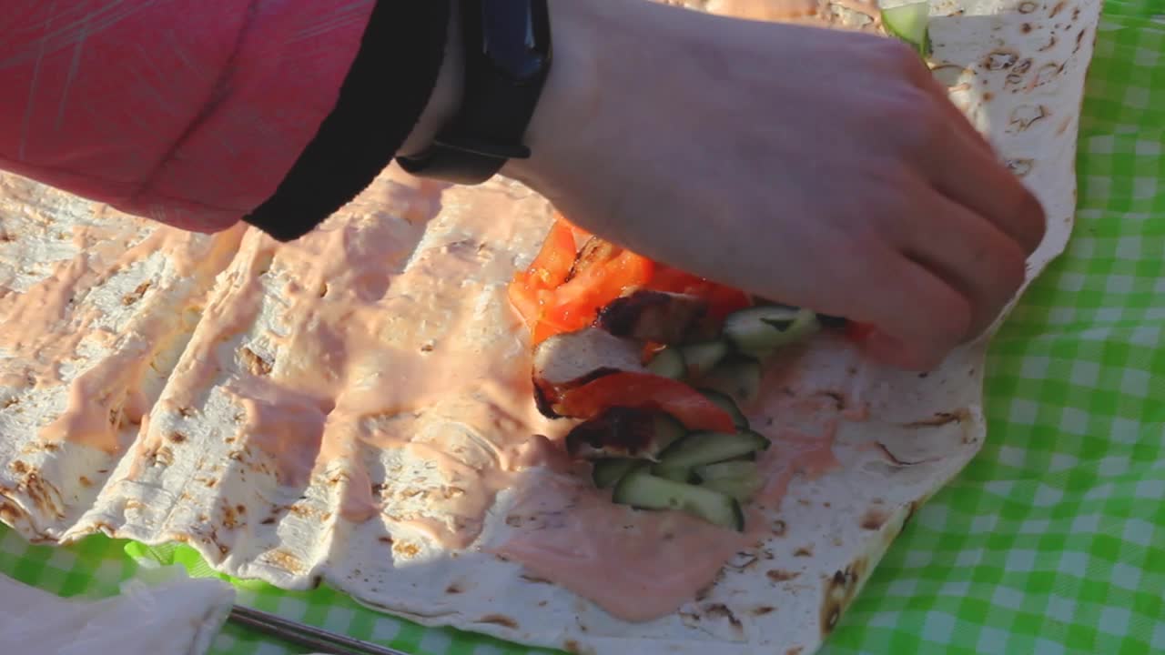 女人们在冬季野餐时收集蔬菜和肉卷，番茄黄瓜片和肉饼上的牛排和酱汁视频下载