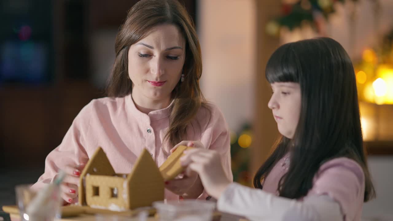 漂亮的白种人女人和漂亮的女孩在家里谈论烹饪姜房子在新年在客厅。快乐自信年轻的妈妈和可爱的女儿在平安夜享受家庭休闲视频素材