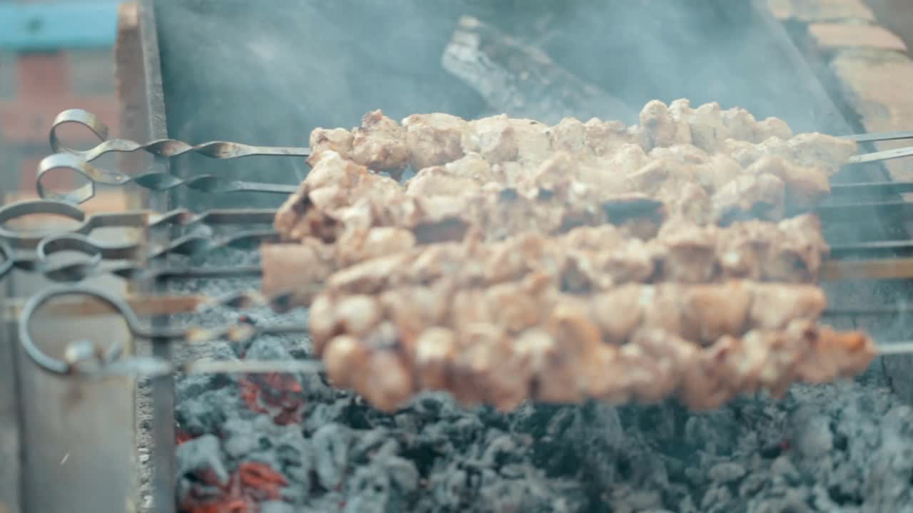 在烤架上煮肉和蔬菜。烧烤在自然界中。烤肉串在烟里。热的食物。视频素材