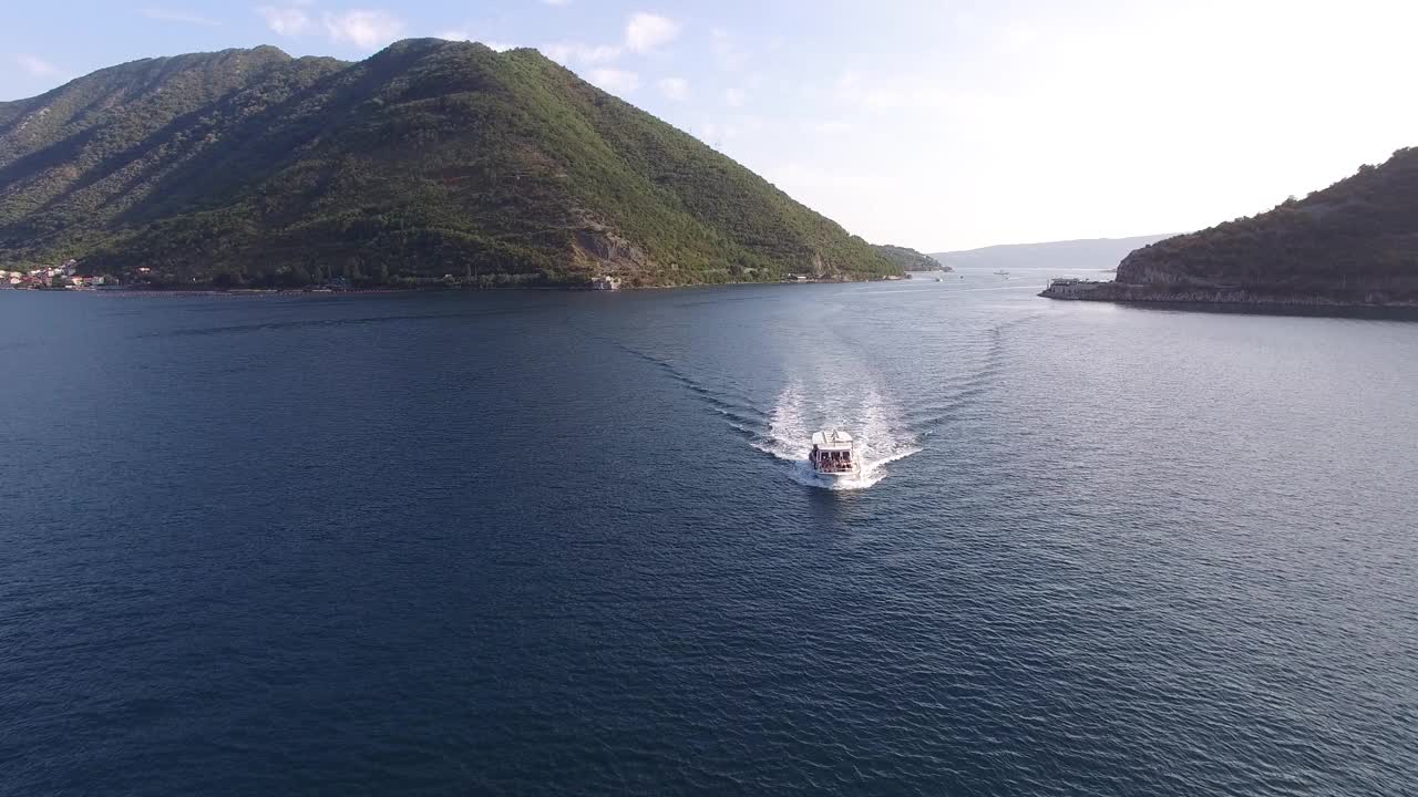 白色的摩托艇在海上驶过多山的海岸视频素材