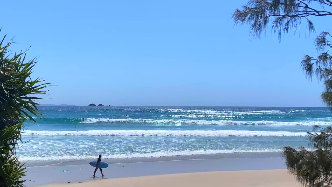 带着冲浪板在热带海滩冲浪视频素材