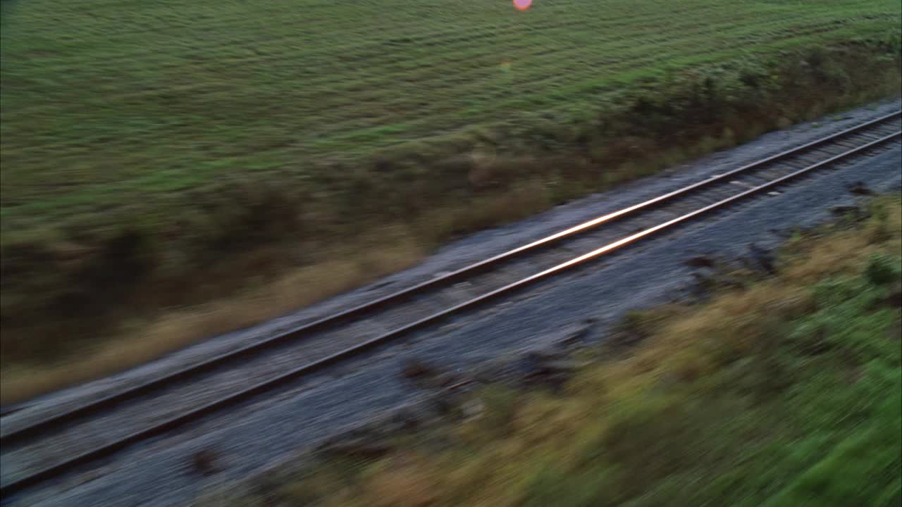 在乡村地区或被草地包围的乡村的铁路或铁路的空中轨道。视频素材