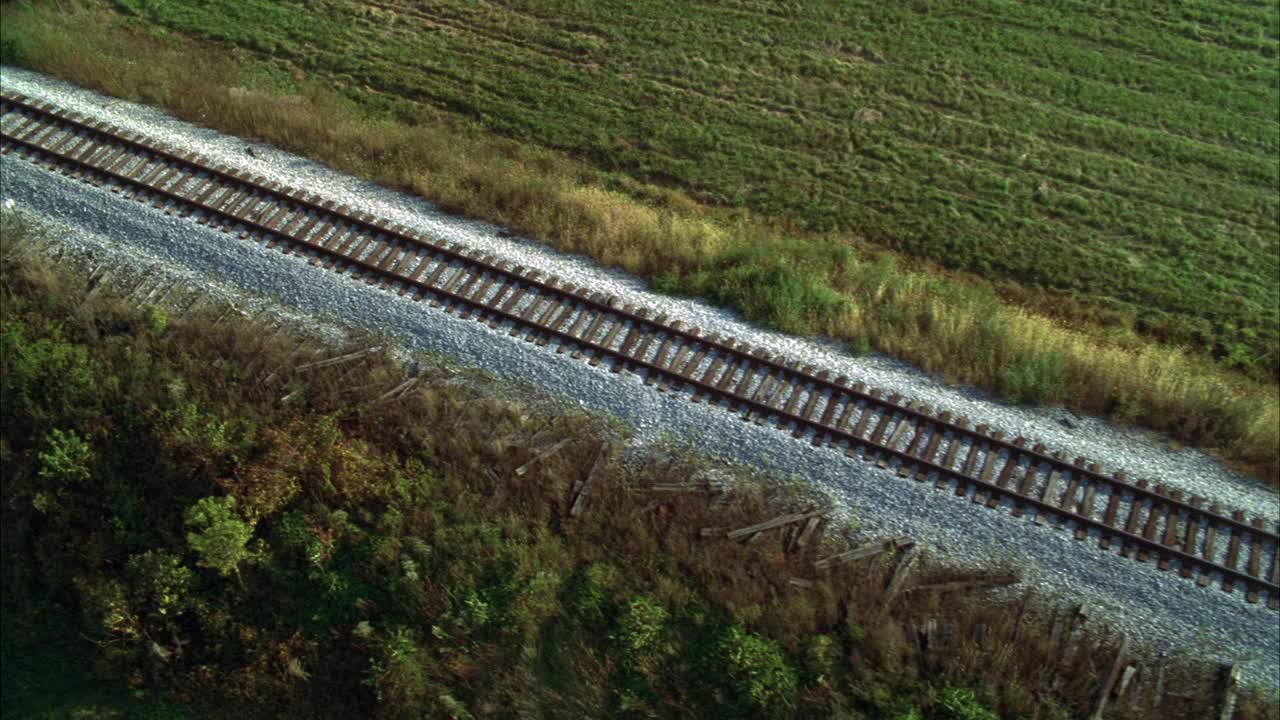 在乡村地区或被草地包围的乡村的铁路或铁路的空中轨道。视频素材