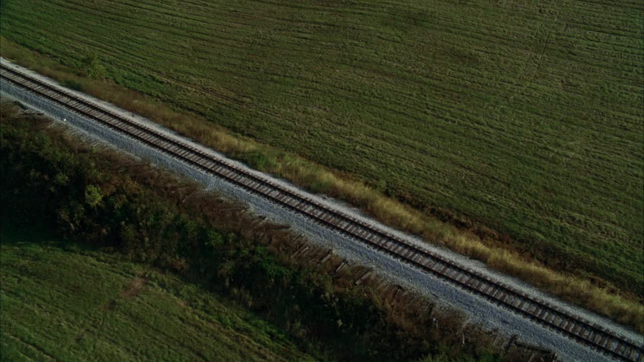 在乡村地区或被草地包围的乡村的铁路或铁路的空中轨道。视频素材