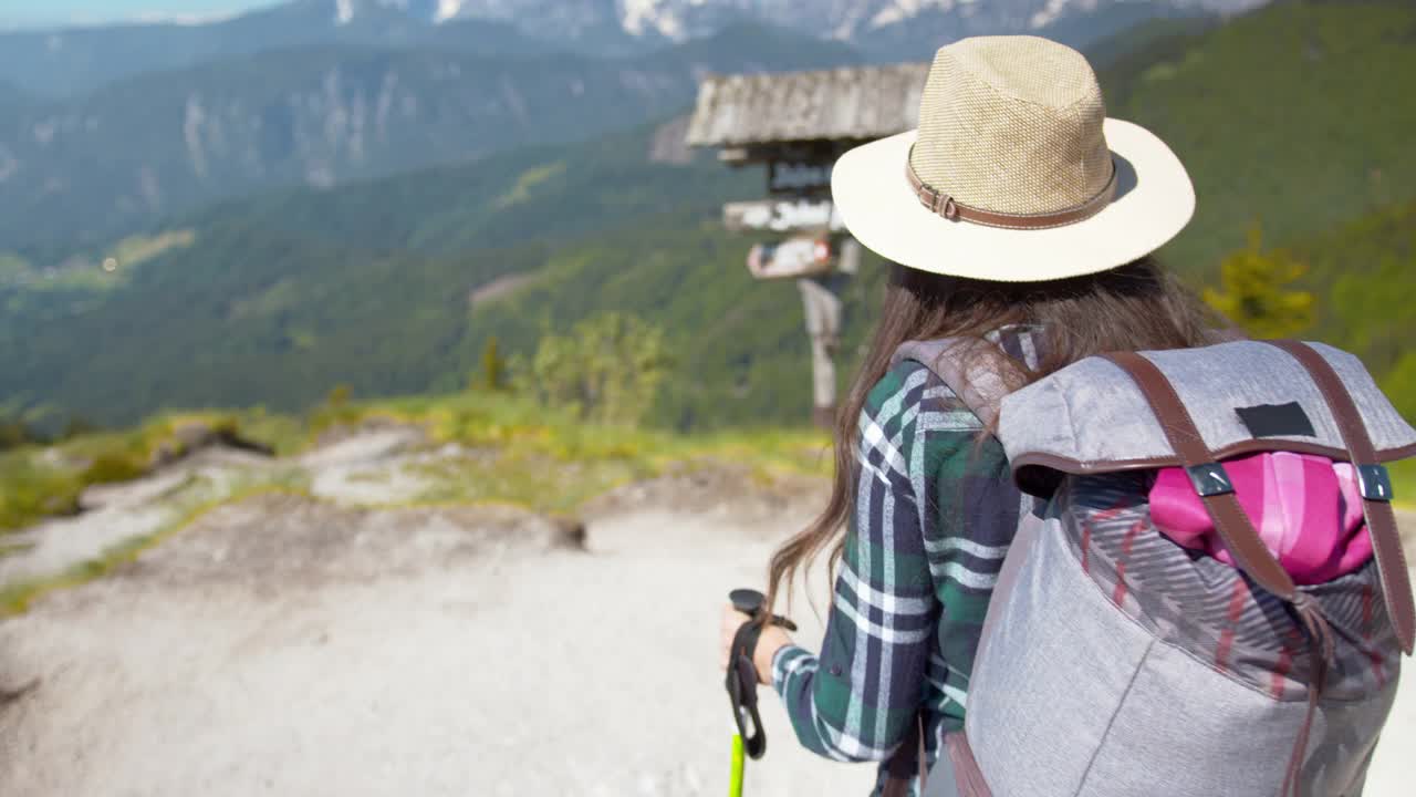 一名年轻的女性徒步旅行者走到山中的一个观察点视频素材