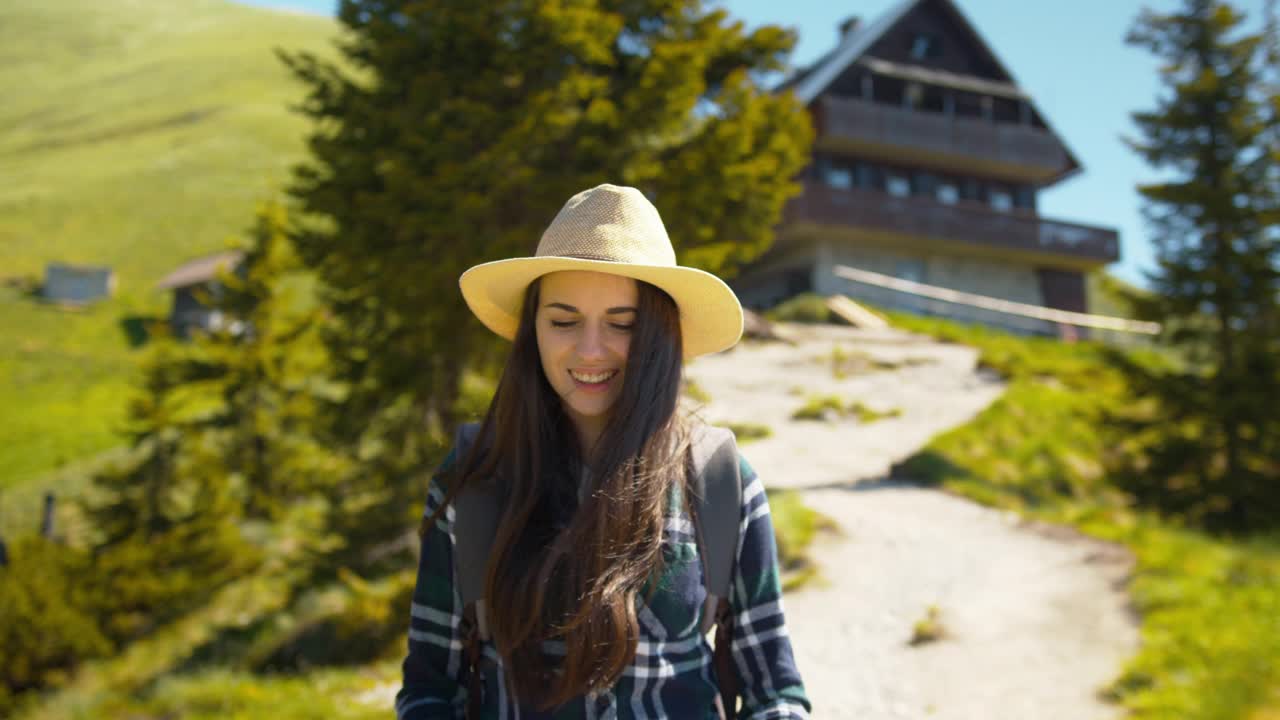 年轻的女徒步旅行者离开山间小屋视频素材