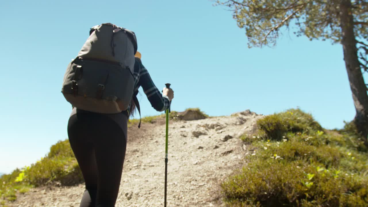 一名年轻的女性徒步旅行者走到山中的一个观察点视频素材