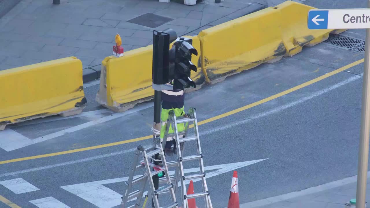 男技术员修理交通灯和灯的异常事故期间，在道路上有很多的交通视频素材