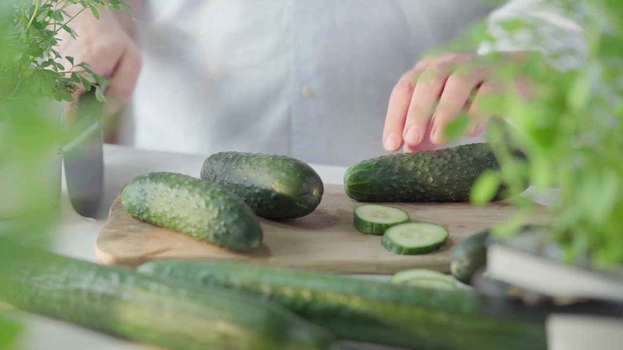 在厨房菜板上切黄瓜的人视频素材