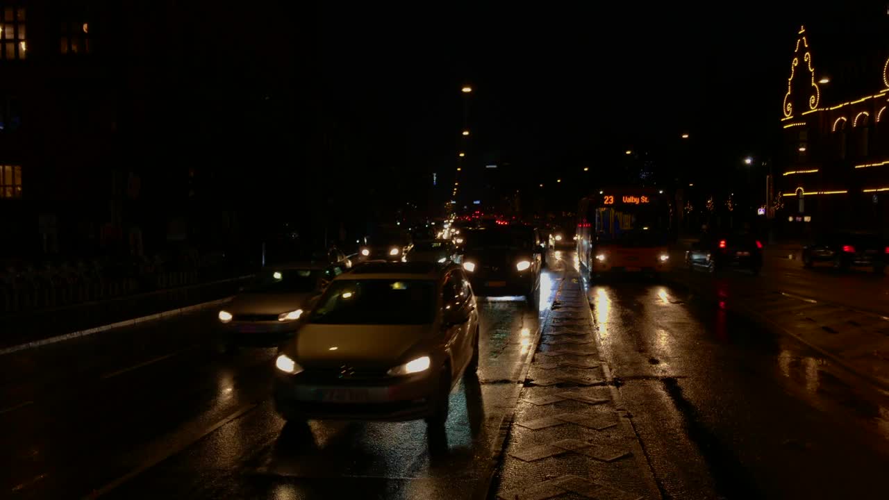 模糊的雨夜城市交通视频，灯光反射在街道上。视频素材