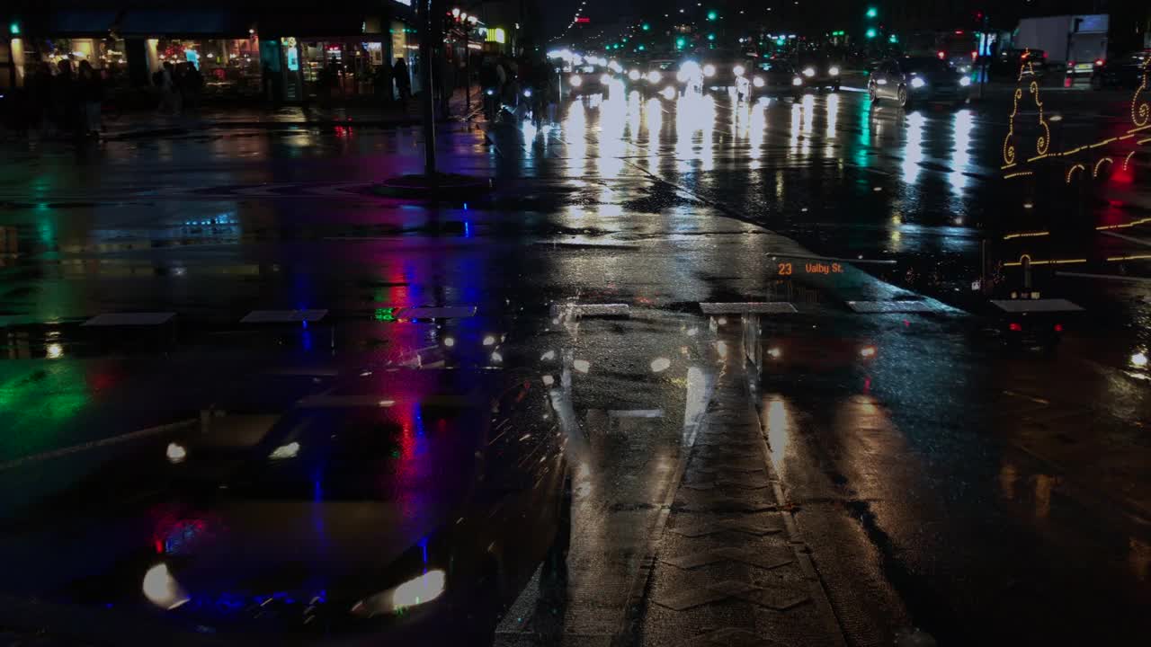 雨夜城市的交通与灯光反射在街道上。视频素材