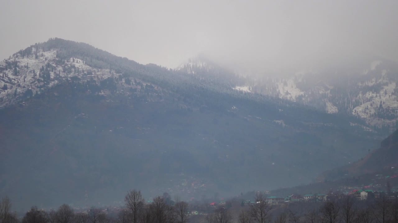 在喜马偕尔邦的马纳里，冬天被雪覆盖的山顶，印度。在冬季，山顶被雪和雾所覆盖。视频素材