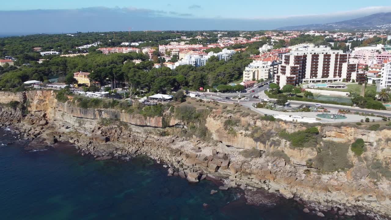 空中摇摄无人机拍摄的岩石Cascais海岸线在葡萄牙通向Casa da Guia和Farol da Guia视频素材